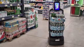 Lucki Bot in a retail setting holding cans of Heineken beer on each platform